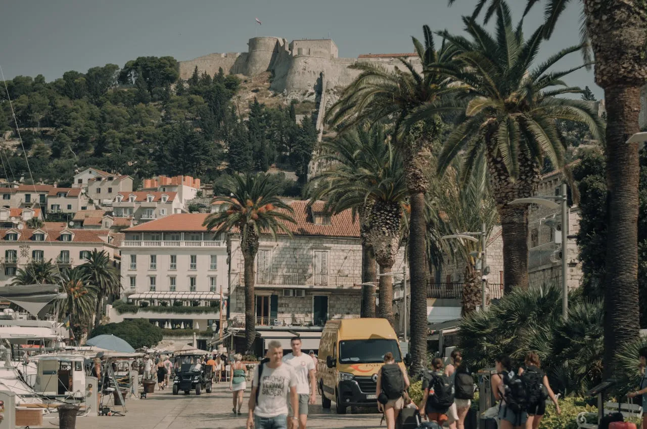 Hvar town promenade with palm trees and Fortica fortress, Croatia.jpg